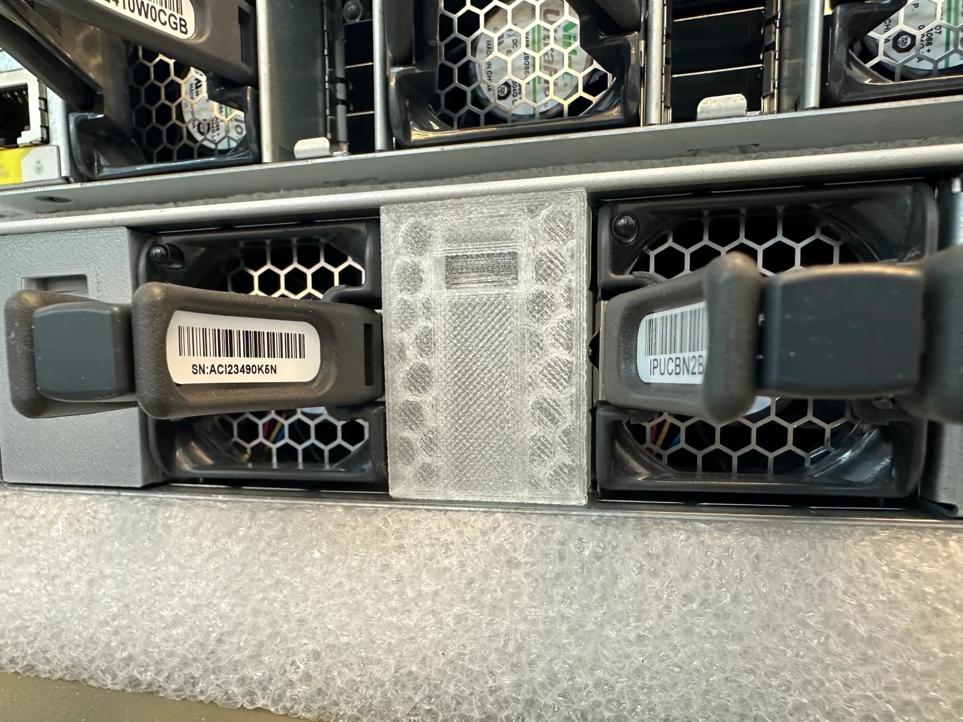 Transparent gedruckte Blende, eingebaut zwischen zwei Lüftermodulen auf der Rückseite eines Switches